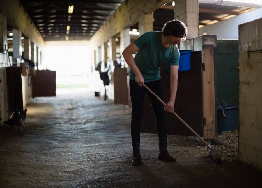 Man sweeping stable